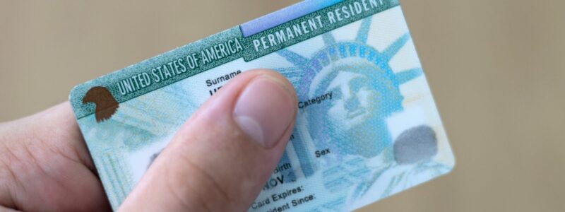 Man,Holding,Us,Permanent,Resident,(green),With,His,Hand.,Immigration